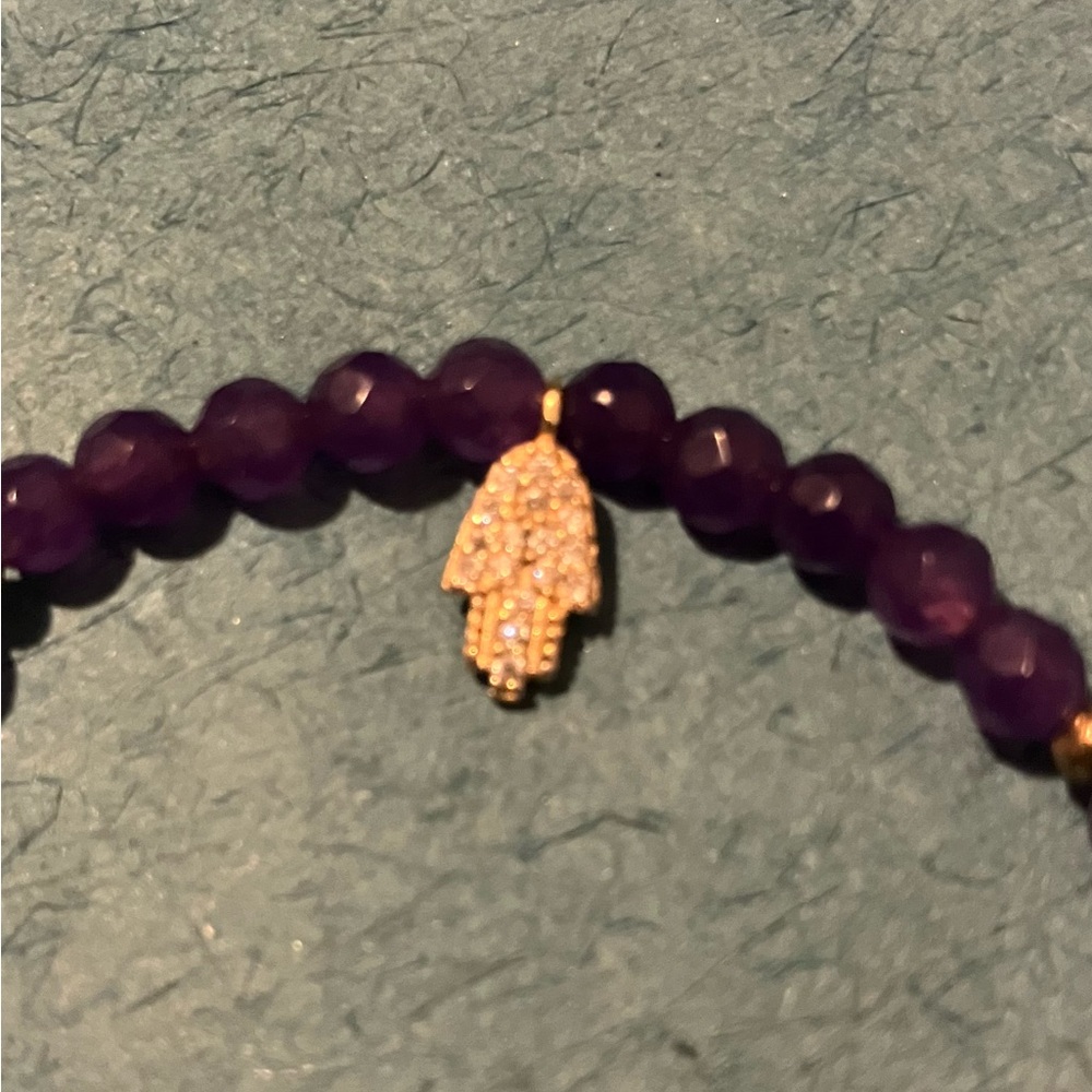 Amethyst bracelet with gold hamsa charm.